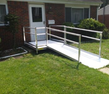 A temporary metal ramp installed from a garden path to a porch